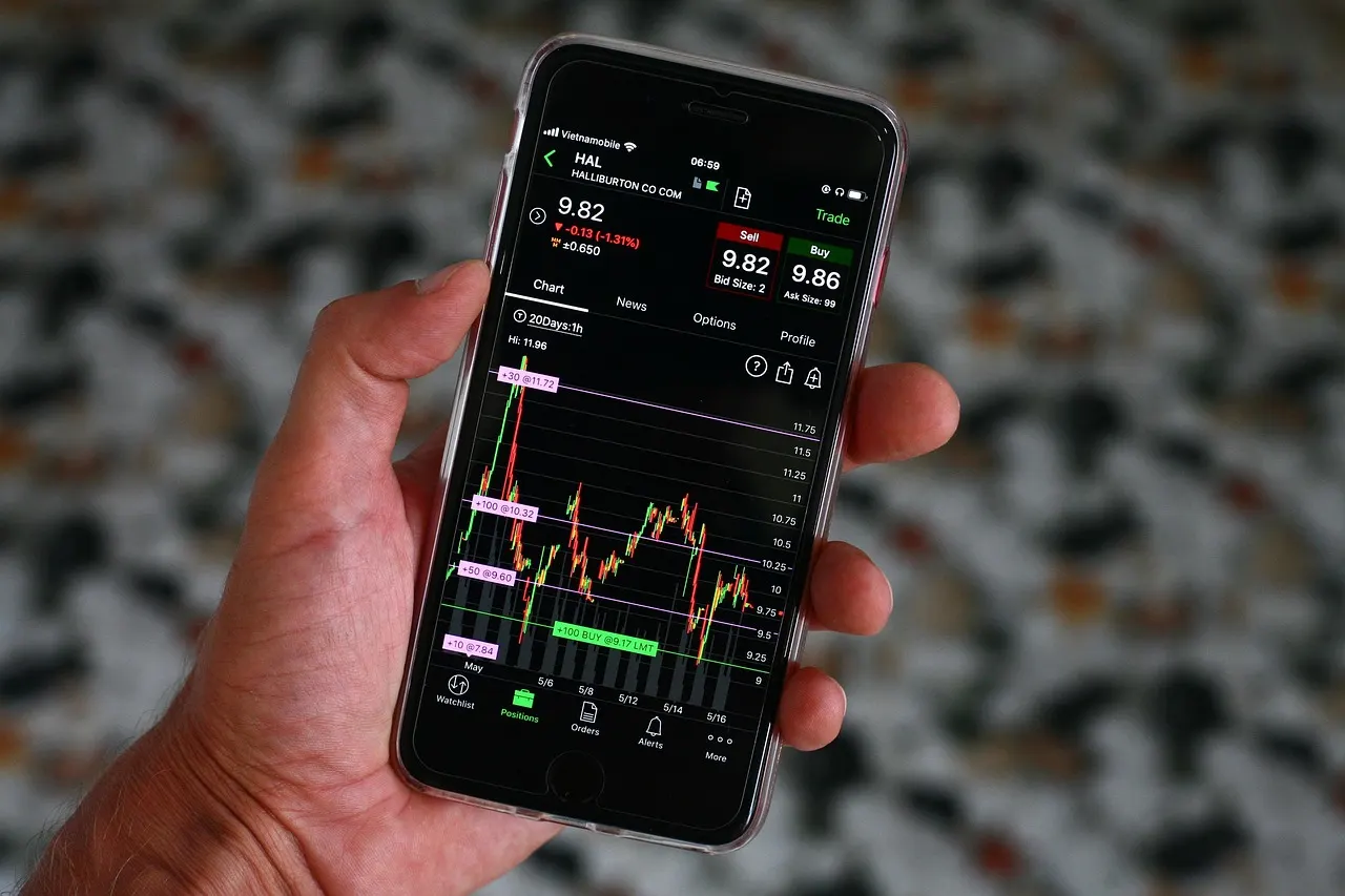 Smartphone displaying red declining stock charts for major technology companies