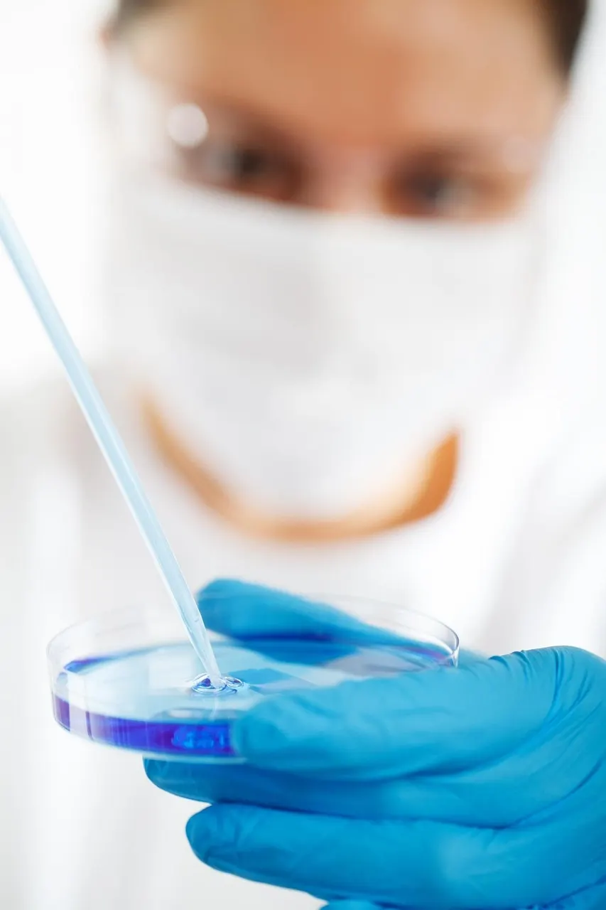 Laboratory researcher studying microplastic particles under a microscope