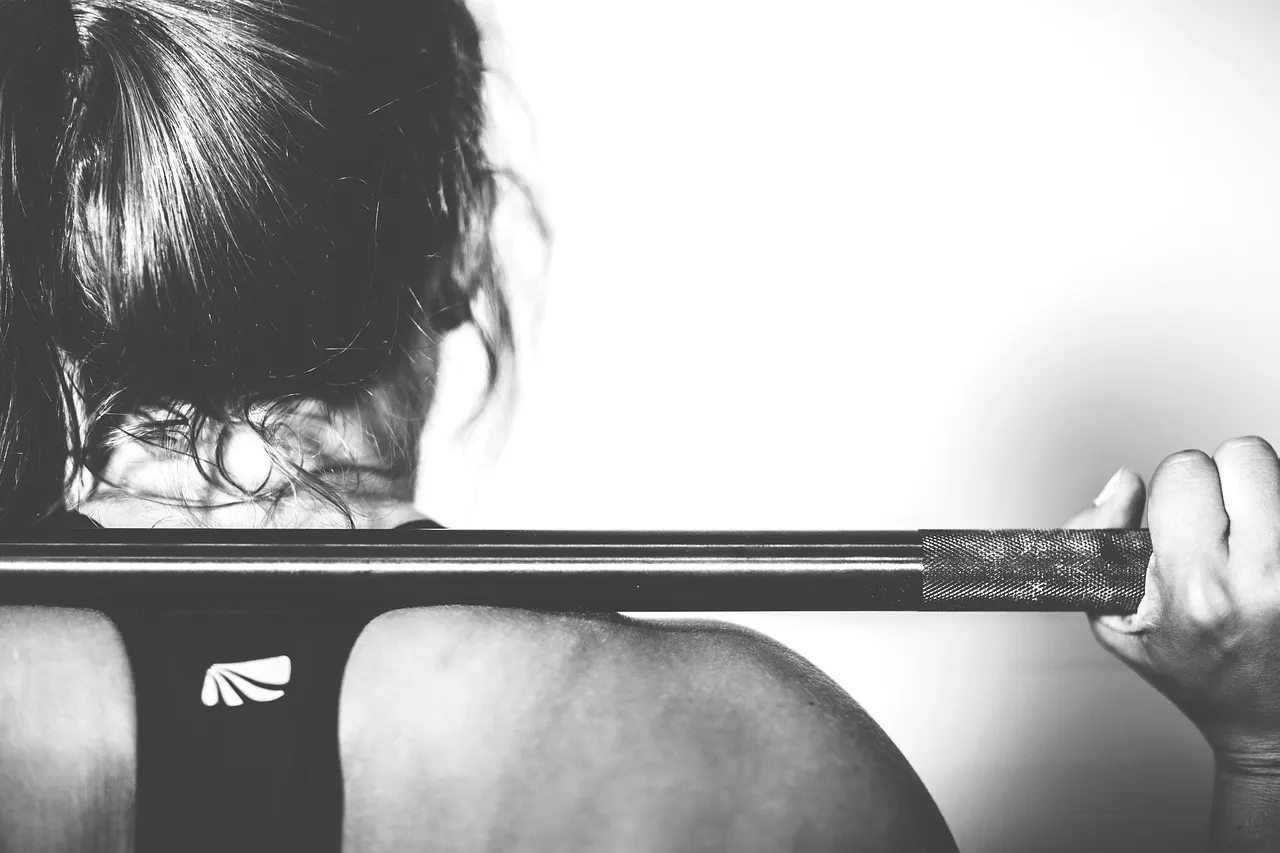 man performing a heavy barbell squat at the start of a workout, illustrating what order should you do exercises in
