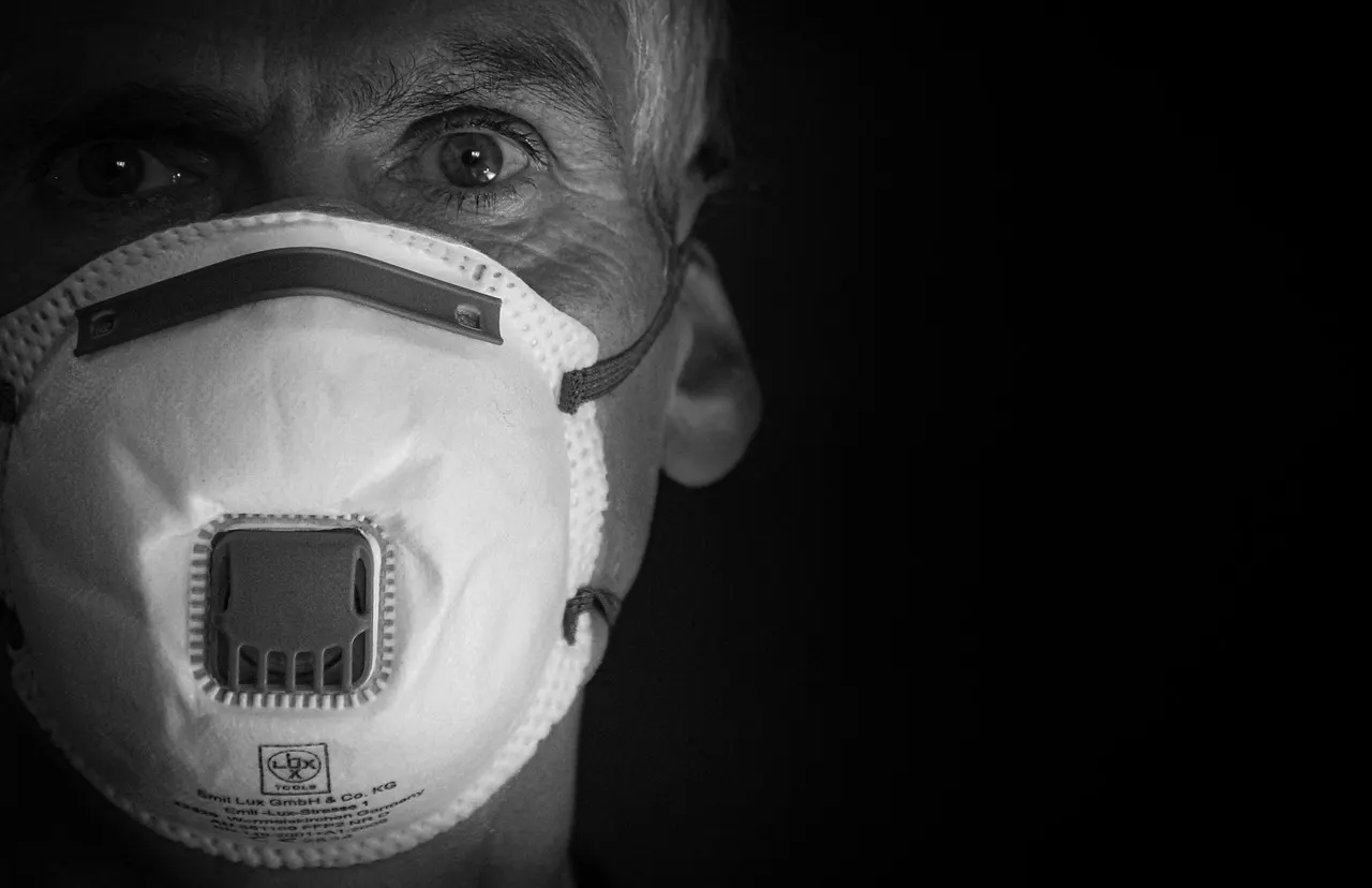 A pedestrian wearing an N95 respirator while walking through heavy wildfire smoke